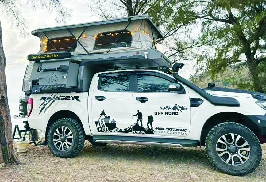 White off-road pickup with the TUYU T1 sloping pop-top camper fitted, parked on a dirt track